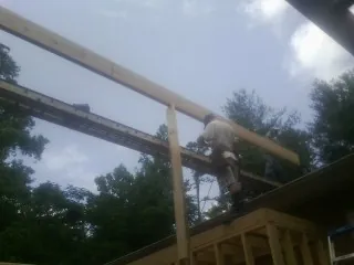 Carpenter setting a ridge beam over a new addition frame — Ice Dam Removal by Roofing Brothers in Three Rivers