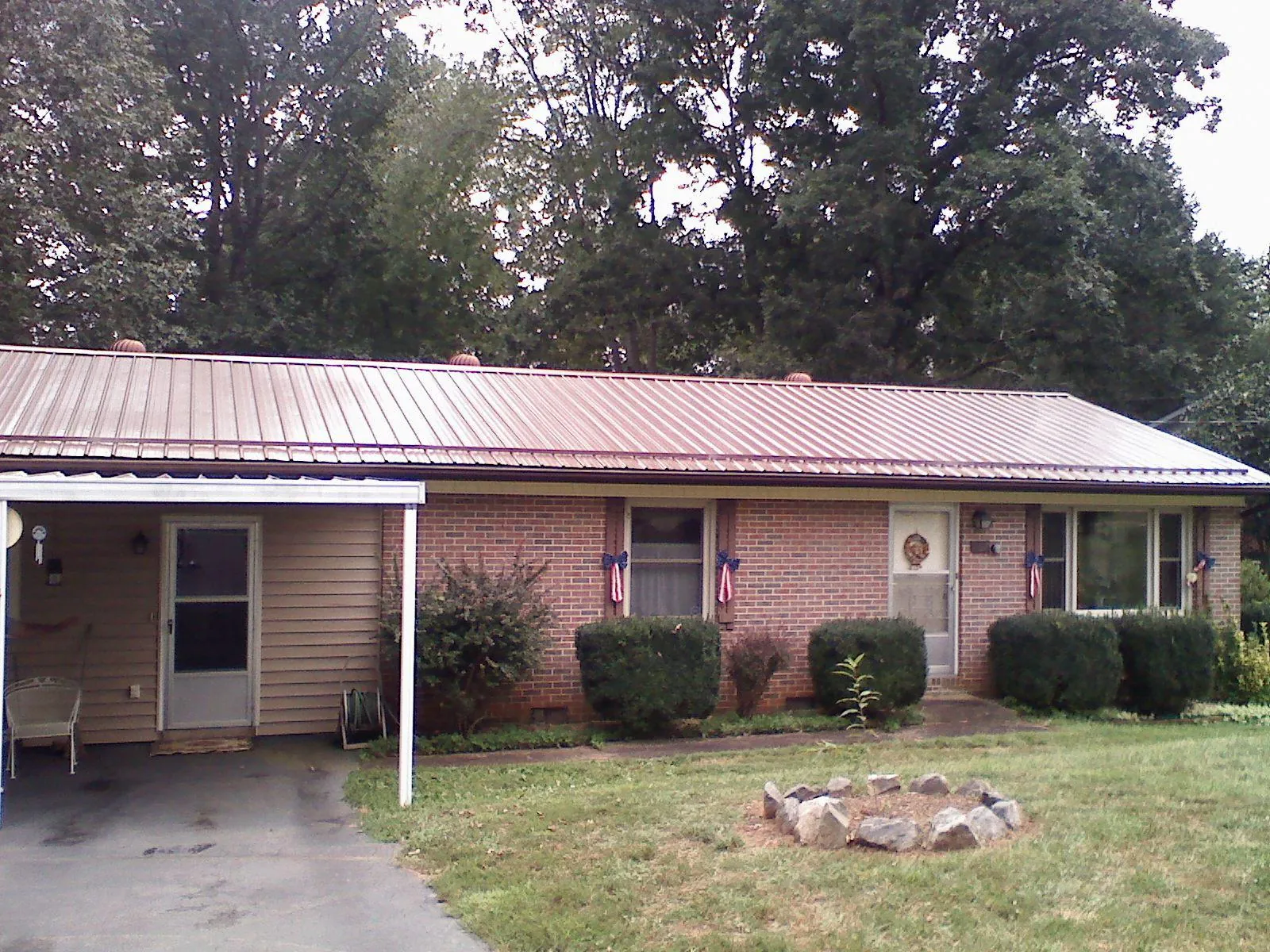 Bronze metal roof and carport on a brick ranch home — Roof Repair work by our crew in Three Rivers